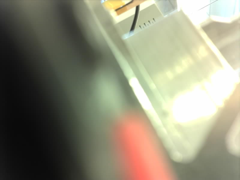 Blurry 800 by 600 test photo from the Arducam, showing a bench with a red object in the foreground.